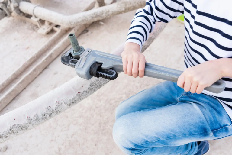 Instalator skręcający złączkę na rurze